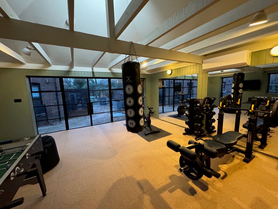 A gym with exercise equipment and a foosball table at Oak Cottage in Somerleyton