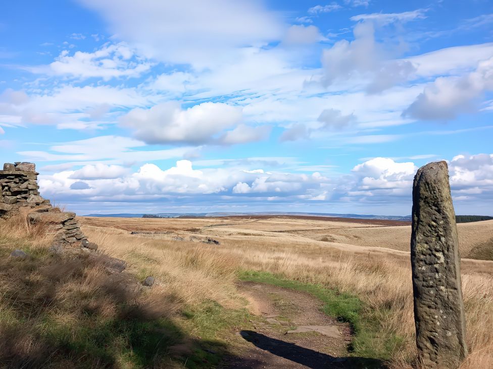 A landscape with a stone and path in a rural area at Penny Cottage in Haworth