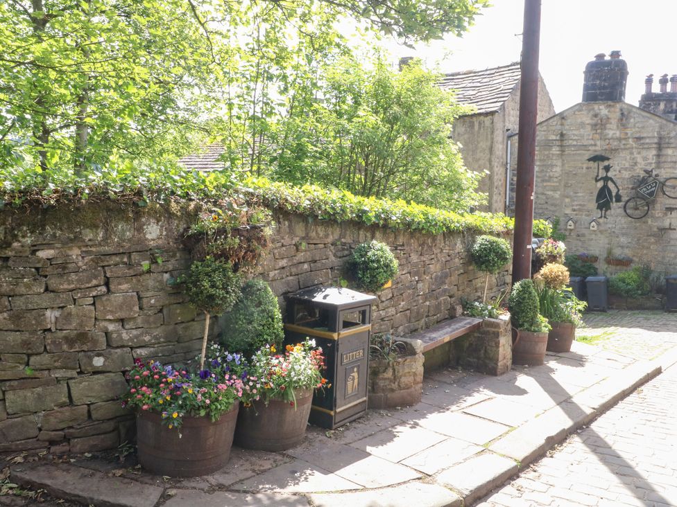 An outdoor area with benches and flower pots at Penny Cottage in Haworth