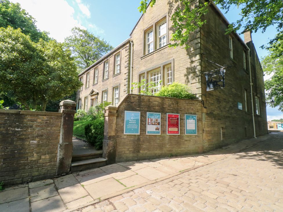 An exterior view of a building with signage and steps at Penny Cottage in Haworth