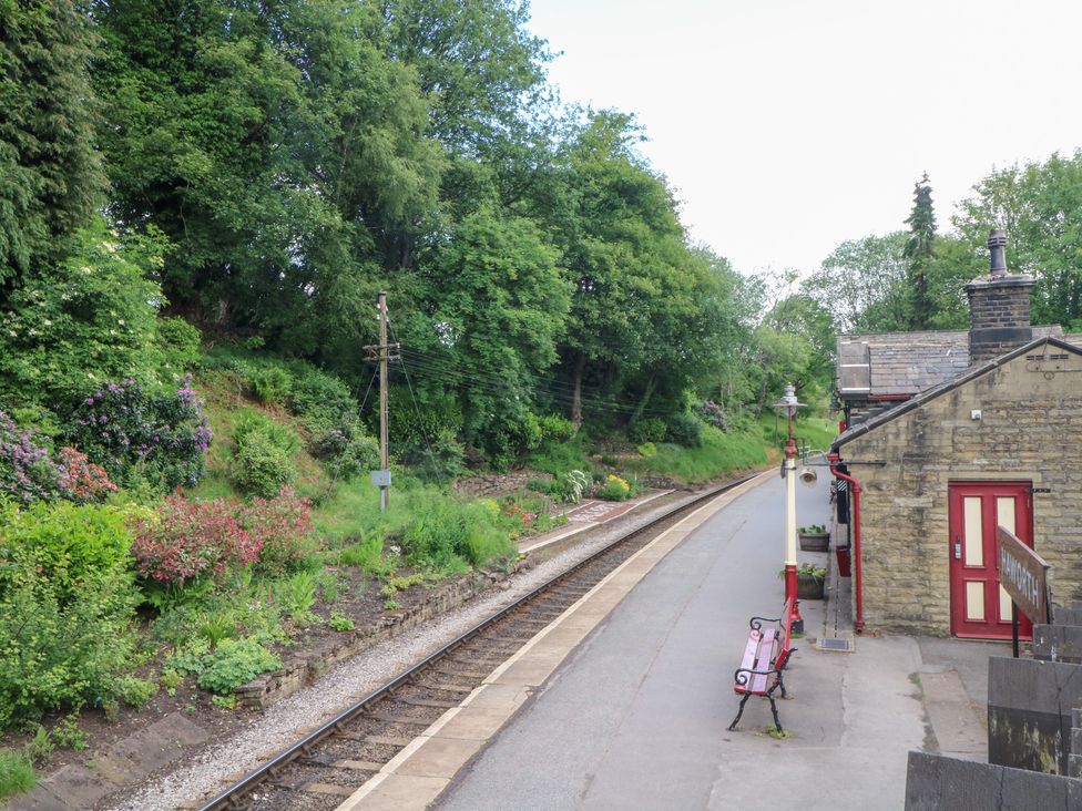 A train station with a platform and track at Penny Cottage in Haworth