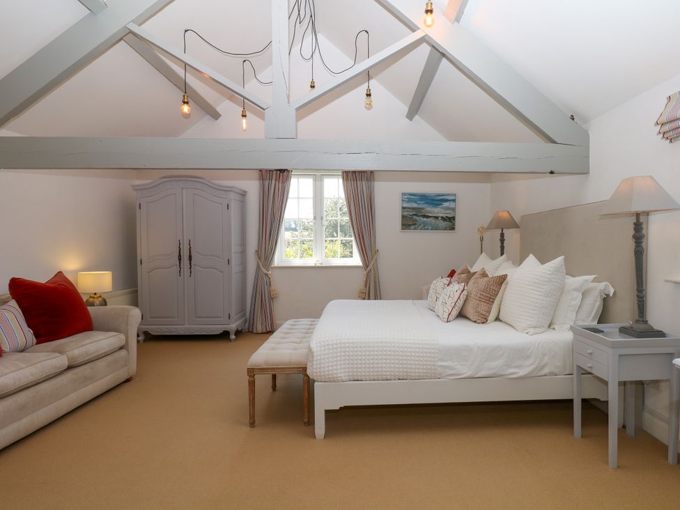 A bedroom with a bed and wardrobe at Apple Mill in Venn Ottery near Sidmouth