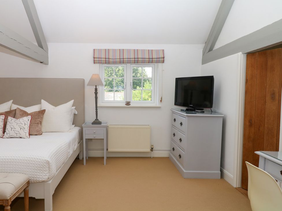 A bedroom with a bed and television at Apple Mill in Venn Ottery near Sidmouth
