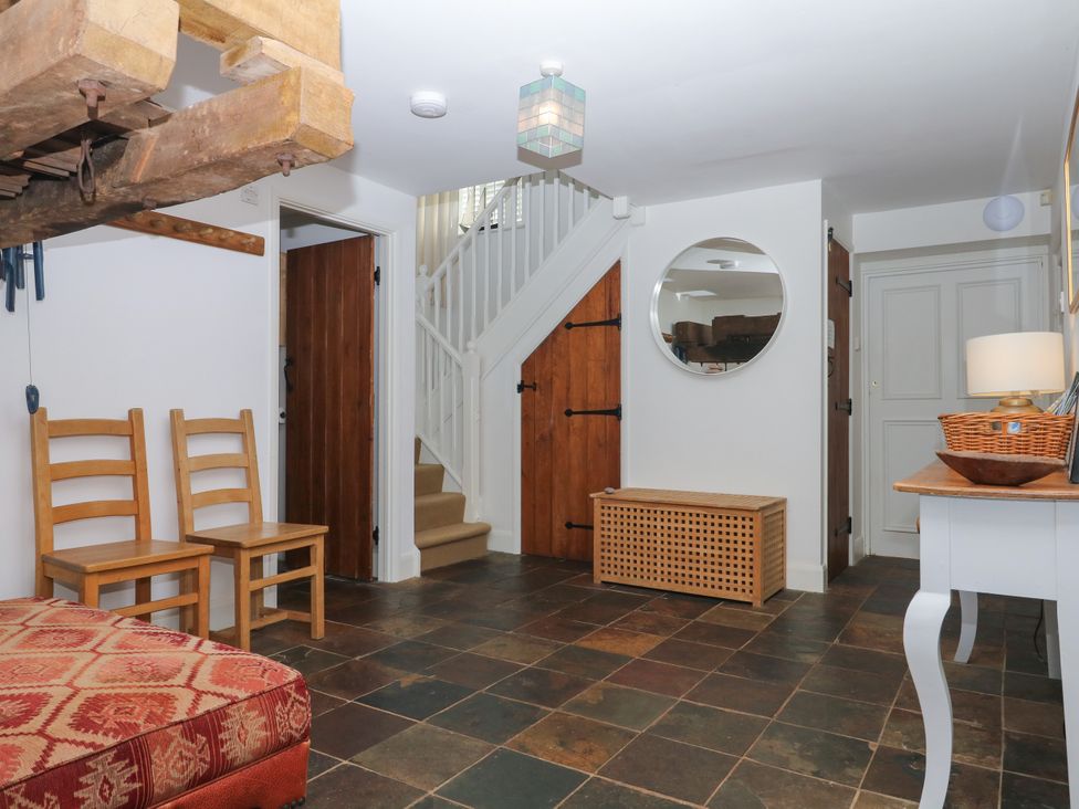 A hallway with chairs and a staircase at Apple Mill Venn Ottery near Sidmouth