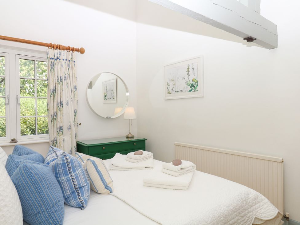 A bedroom with a bed and window at Apple Mill Venn Ottery near Sidmouth