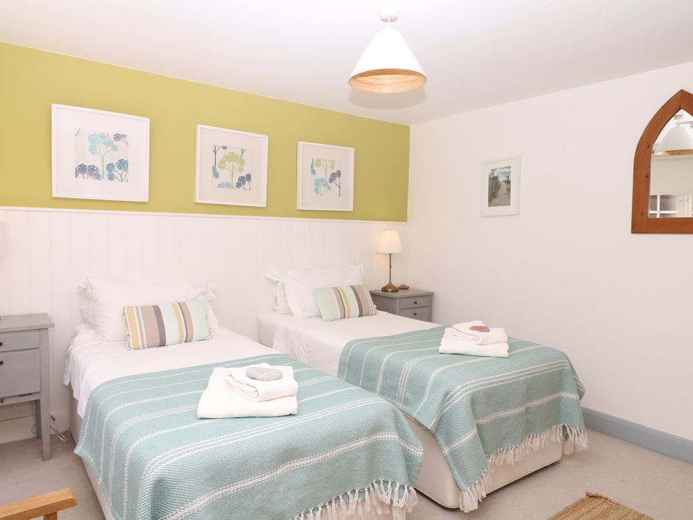 A bedroom with two beds and artwork at Apple Mill Venn Ottery near Sidmouth