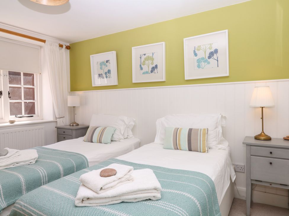 A bedroom with two single beds and bedside tables at Apple Mill Venn Ottery near Sidmouth