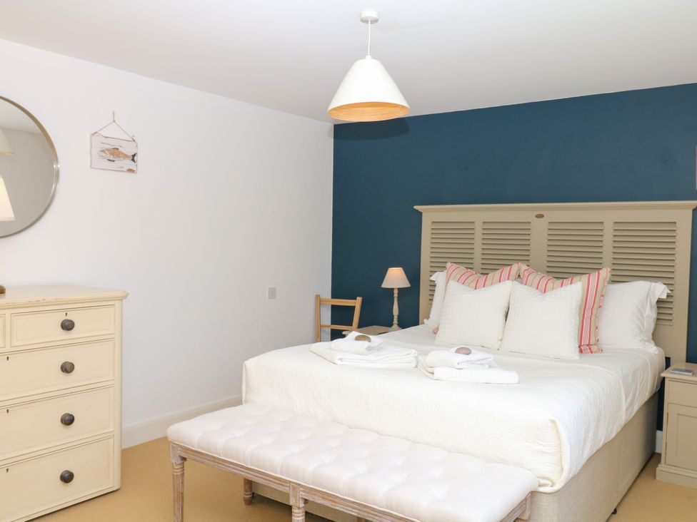 A bedroom with a bed and dresser at Apple Mill in Venn Ottery near Sidmouth