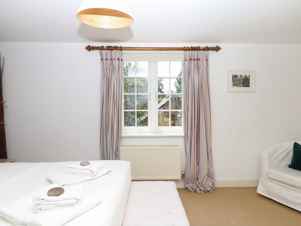 A bedroom with a bed and towels on it at Apple Mill Venn Ottery near Sidmouth