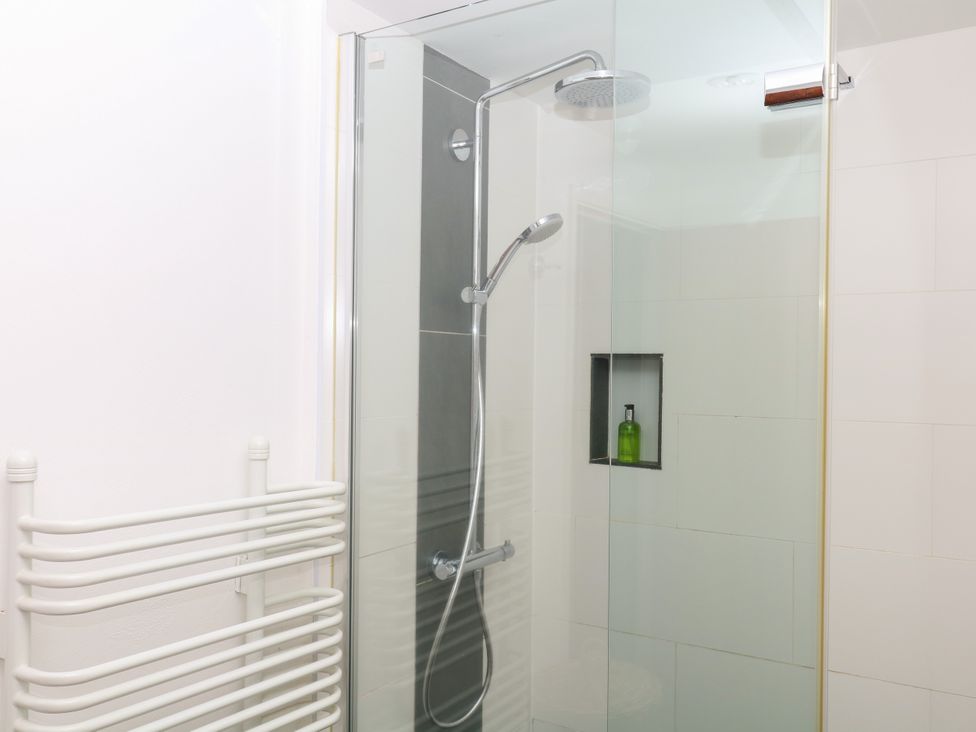 A shower area with glass enclosure and towel rail at Apple Mill in Venn Ottery near Sidmouth