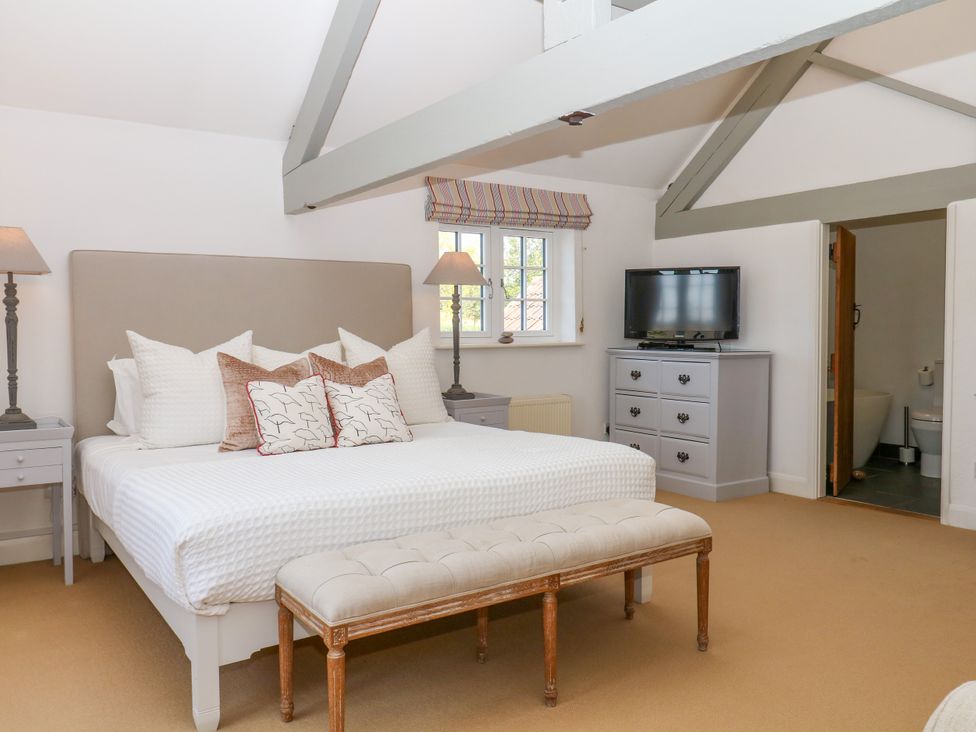 A bedroom with a bed and television at Apple Mill Venn Ottery near Sidmouth