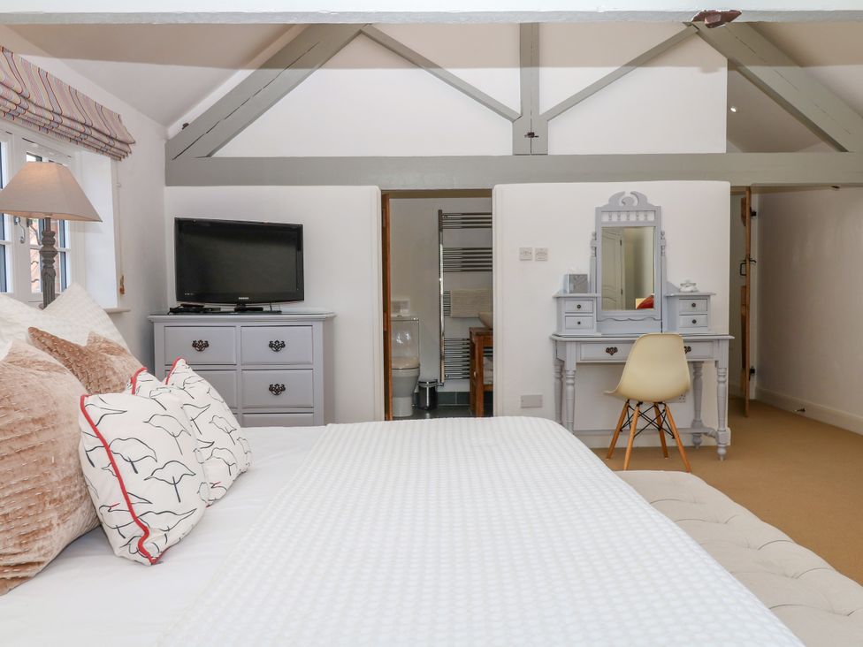 A bedroom with a bed and TV at Apple Mill in Venn Ottery near Sidmouth