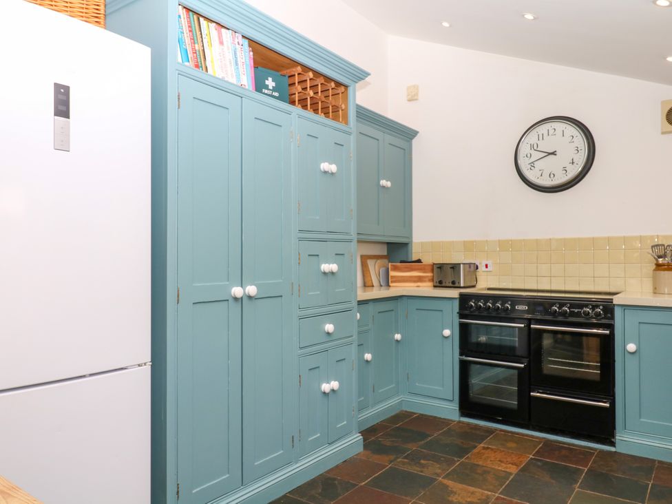 A kitchen with a fridge and oven at Apple Mill in Venn Ottery near Sidmouth