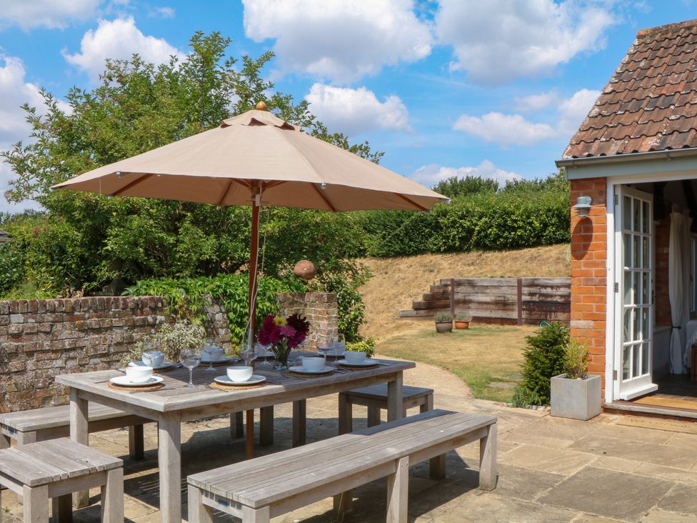 An outdoor dining table with umbrella at Apple Mill Venn Ottery near Sidmouth