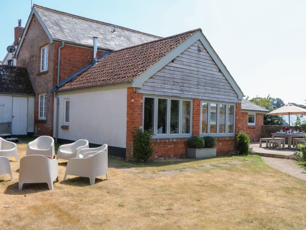 A house with garden seating and a table under an umbrella at Apple Mill in Venn Ottery near Sidmouth
