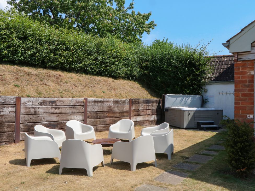 A garden with chairs and a hot tub at Apple Mill in Venn Ottery near Sidmouth