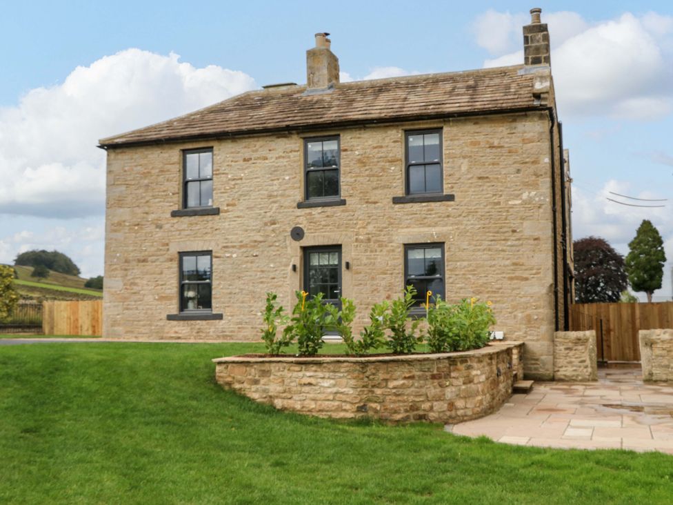 A house with windows and a front door surrounded by grass at Eastfield Farm in Barnard Castle