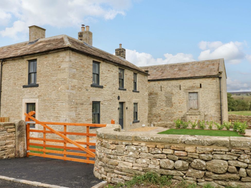 A house with a stone wall and an orange gate at Eastfield Farm in Barnard Castle