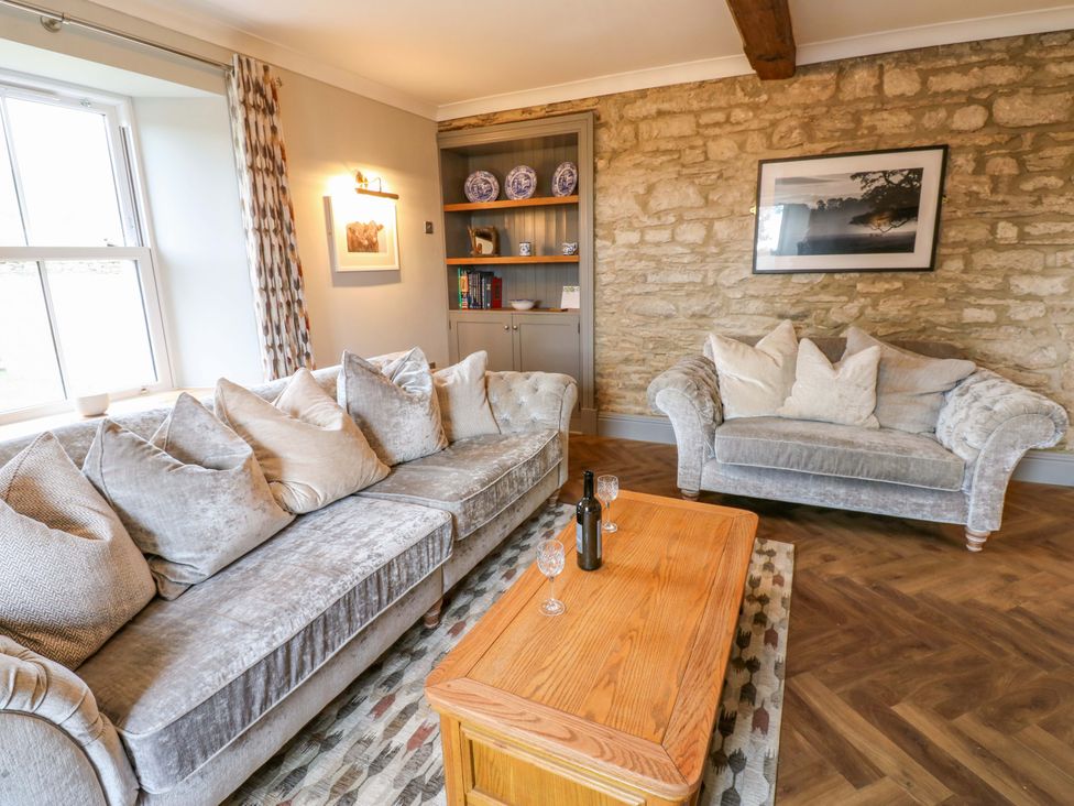 A living room with a sofa, coffee table, and bookshelf at Eastfield Farm Barnard Castle