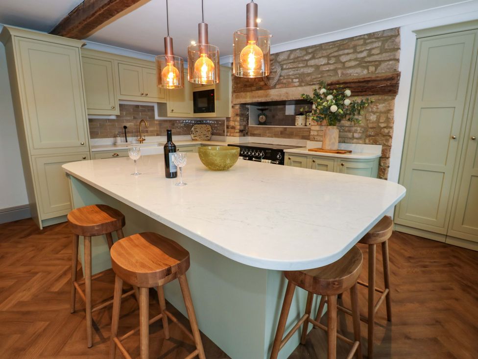 A kitchen with a large island and stools at Eastfield Farm in Barnard Castle