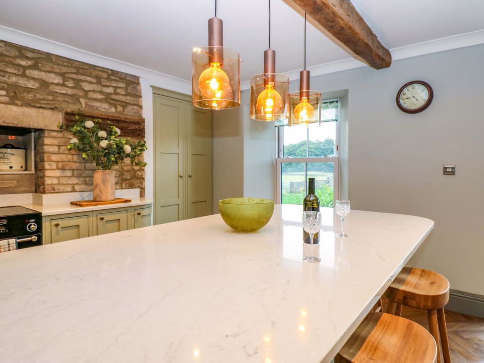 A kitchen with a large island and bar stools at Eastfield Farm in Barnard Castle