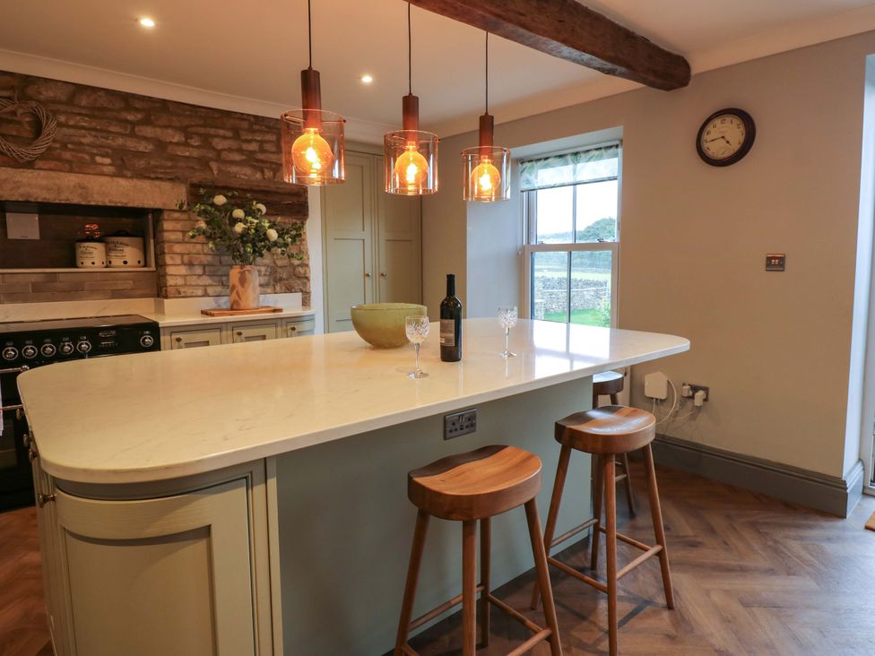 A kitchen with a large island and bar stools at Eastfield Farm in Barnard Castle