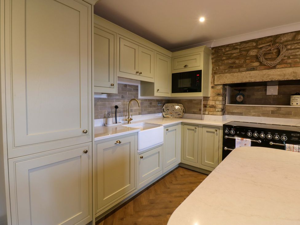 A kitchen with cupboards, sink, and oven at Eastfield Farm in Barnard Castle