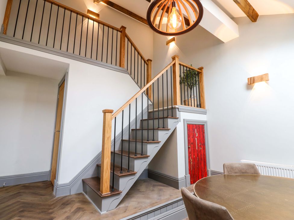 A staircase with wooden handrail and table at Eastfield Farm Barnard Castle