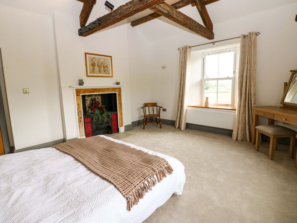 A bedroom with a fireplace and dressing table at Eastfield Farm in Barnard Castle