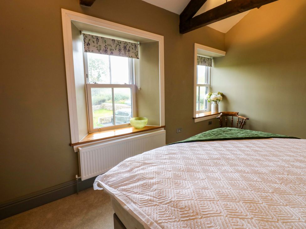 A bedroom with a bed and windows at Eastfield Farm in Barnard Castle