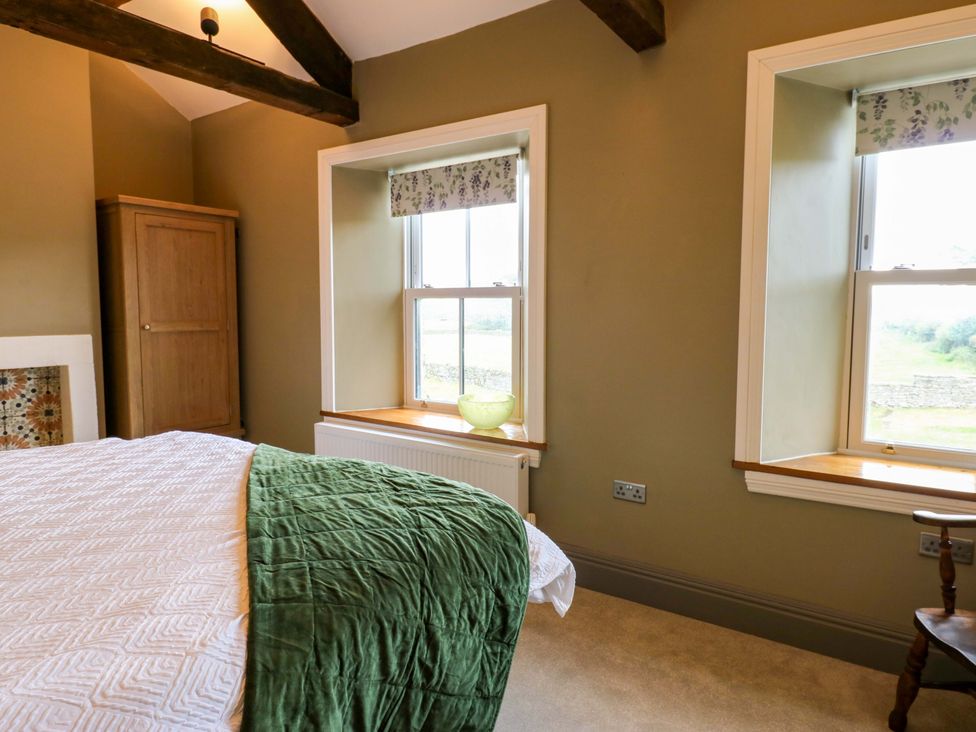 A bedroom with a bed and windows at Eastfield Farm in Barnard Castle