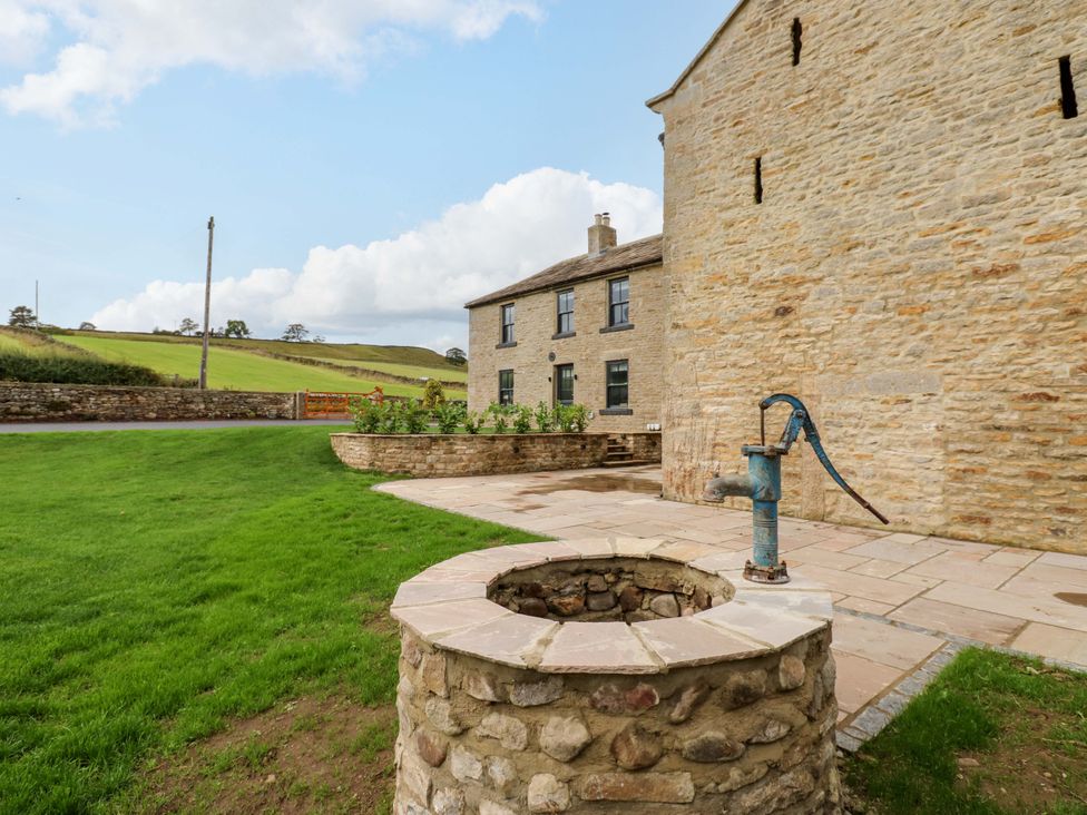 A well with a pump next to a stone building at Eastfield Farm in Barnard Castle