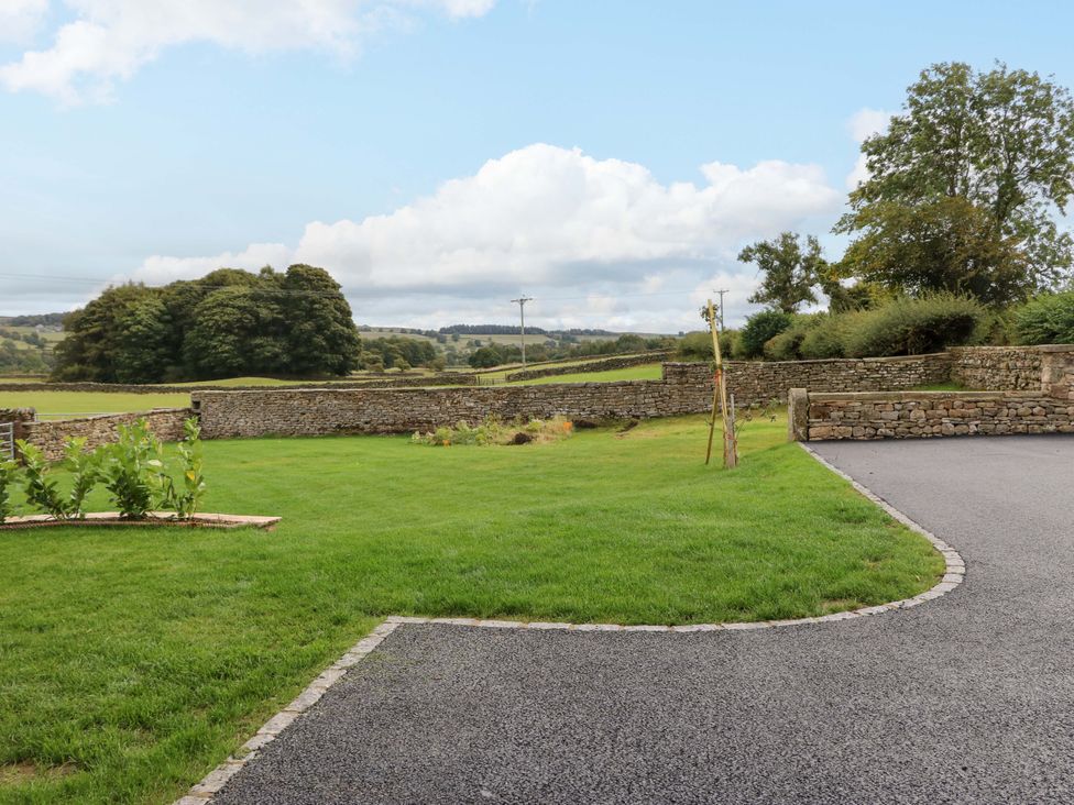 A garden with stone walls and trees at Eastfield Farm in Barnard Castle