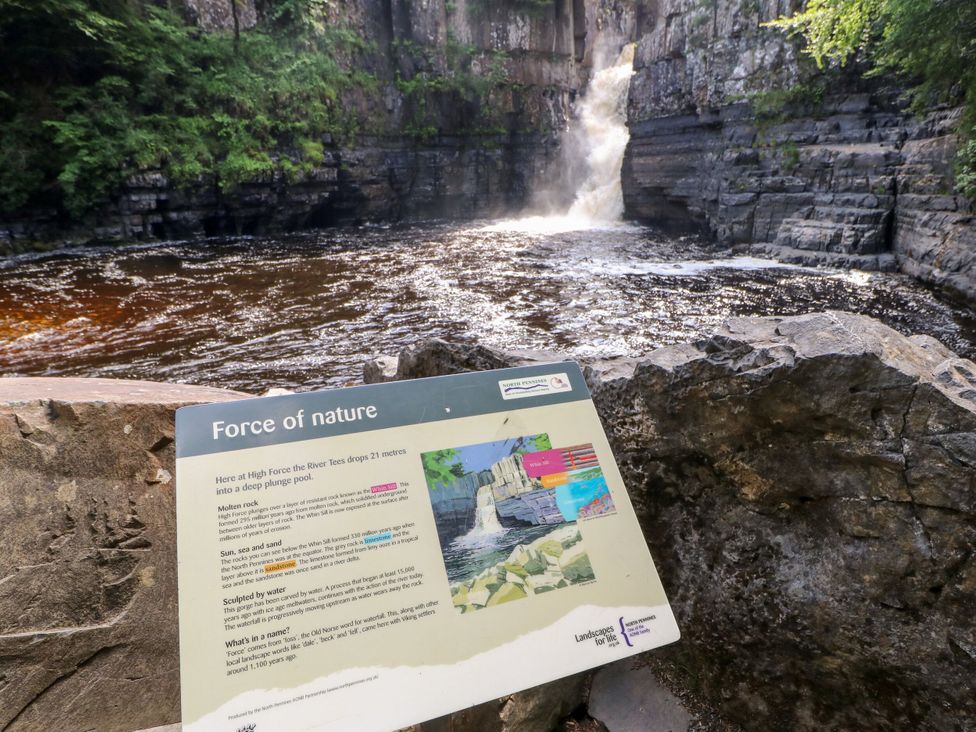 A waterfall at High Force with information sign at High Force, Barnard Castle