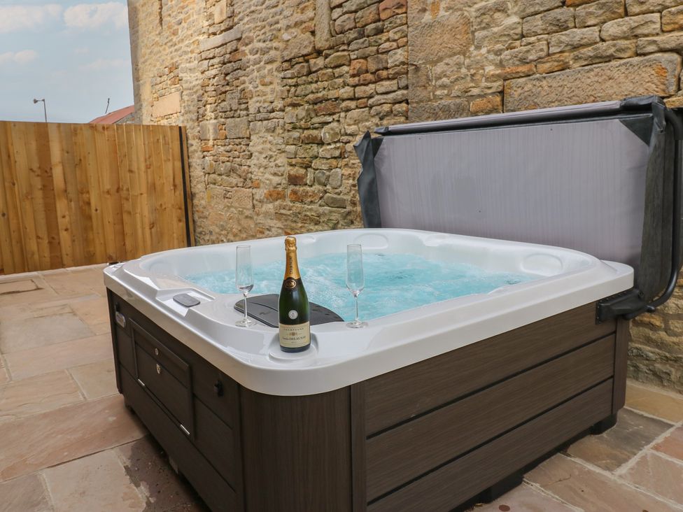 A hot tub with champagne and glasses in an outdoor area at Eastfield Farm Mickleton, Teesdale