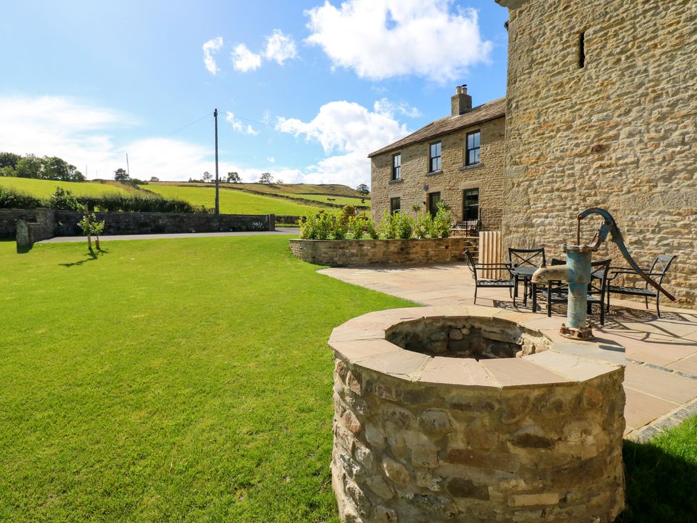 An outdoor area with a stone well and seating at Eastfield Farm Mickleton, Teesdale