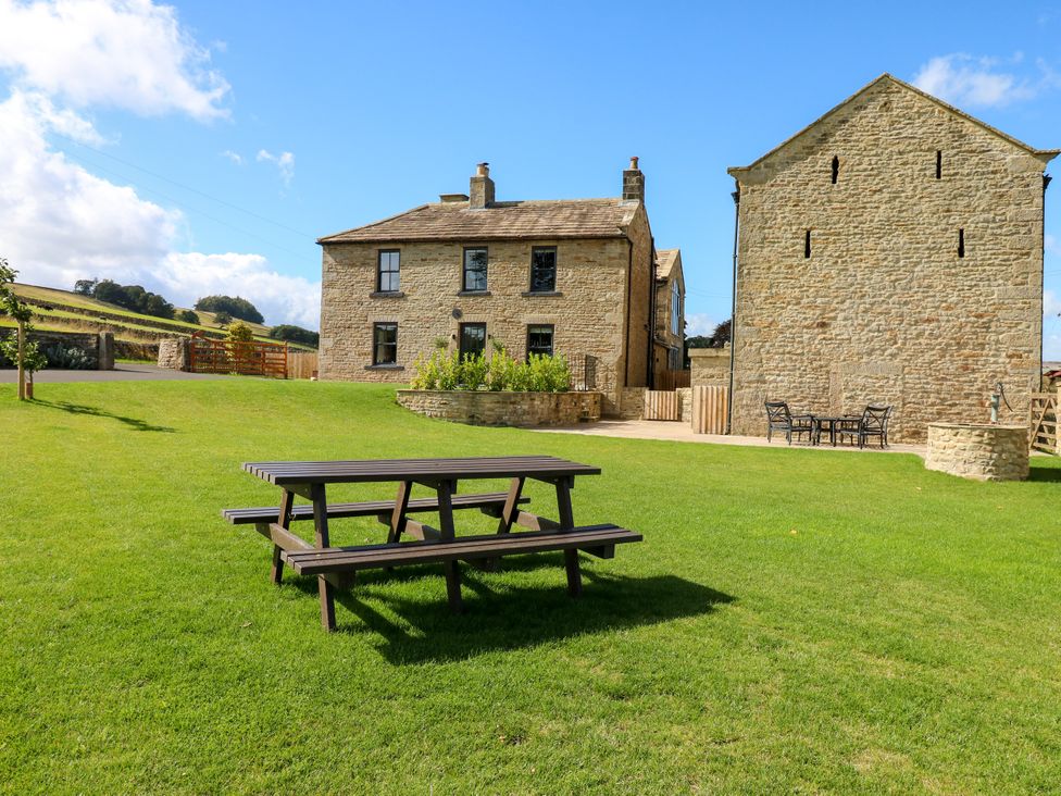 A garden with a house and outdoor seating at Eastfield Farm in Mickleton, Teesdale