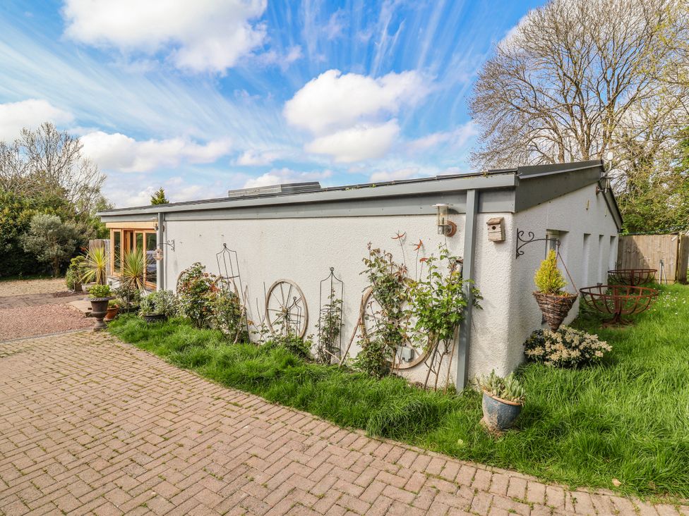 An exterior view of a building with plants and pathways at Burlodge Swimbridge near Barnstaple
