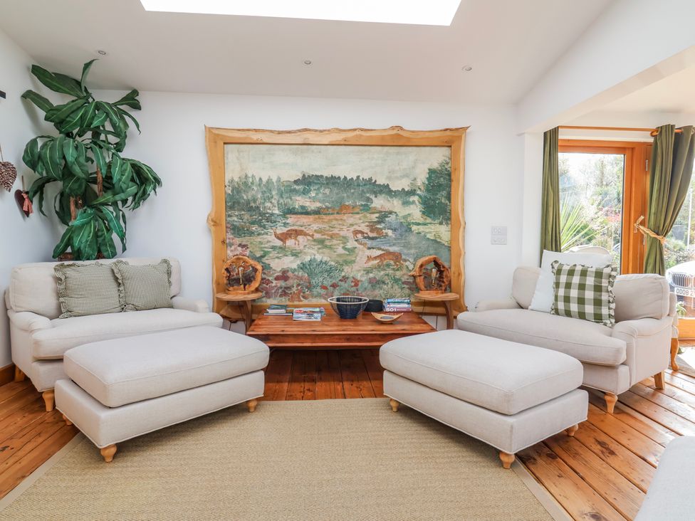 A living room with seating and a wall tapestry at Burlodge in Swimbridge near Barnstaple