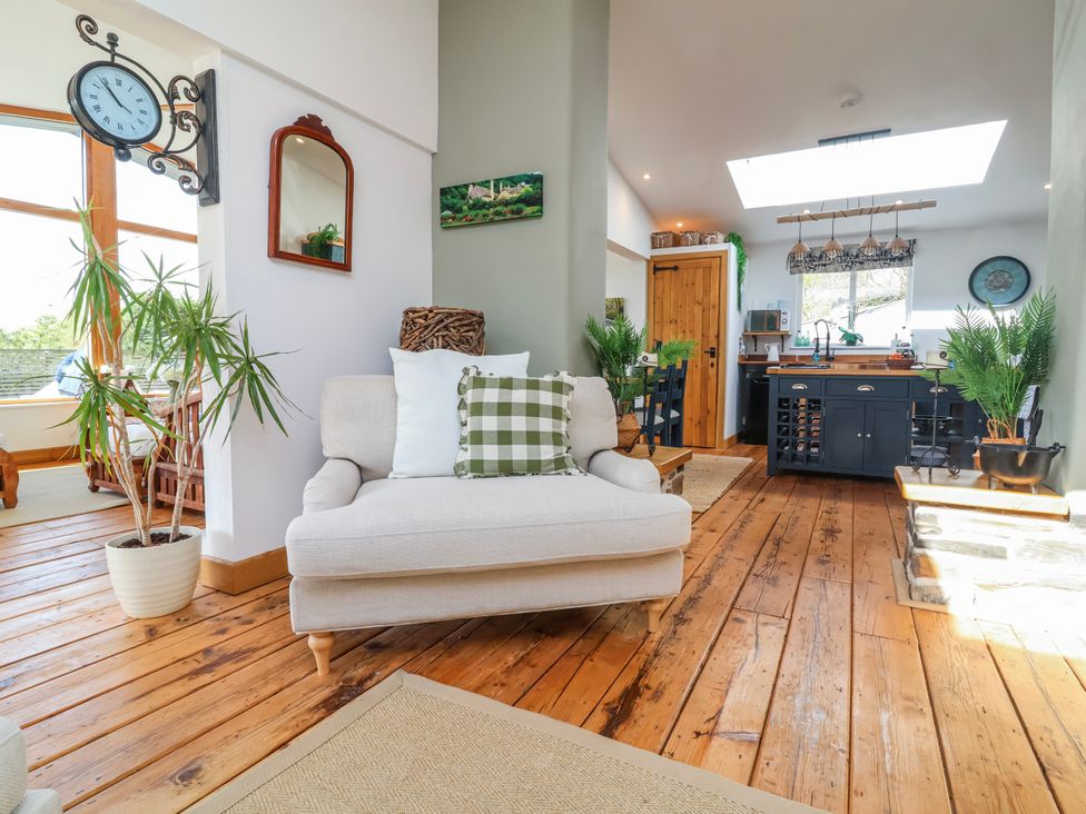 A living room with a sofa and clock at Burlodge in Swimbridge near Barnstaple