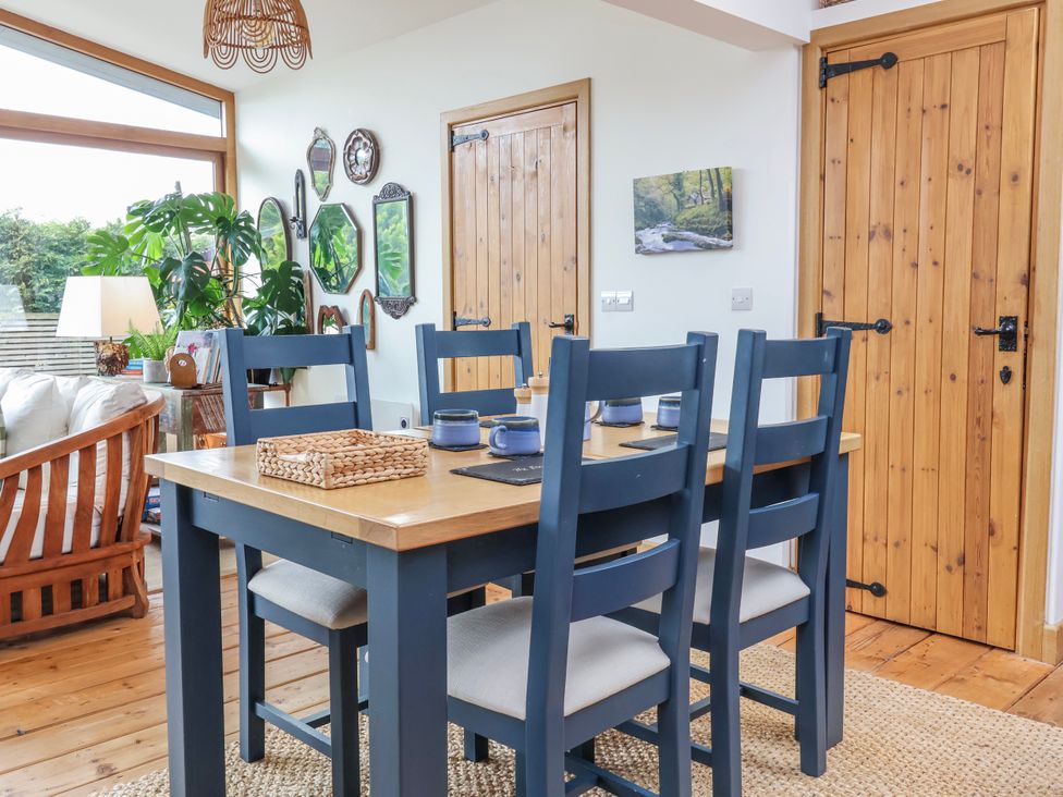A dining room with a table and chairs at Burlodge Swimbridge near Barnstaple