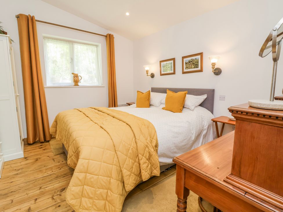 A bedroom with a bed and bedside table at Burlodge Swimbridge near Barnstaple