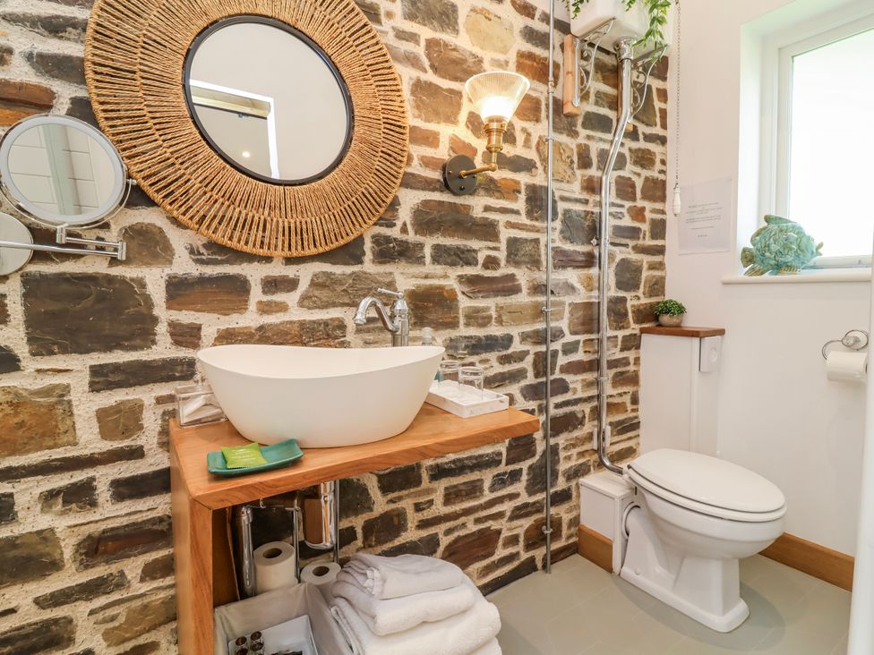 A bathroom with a sink, toilet, and mirror at Burlodge Swimbridge near Barnstaple