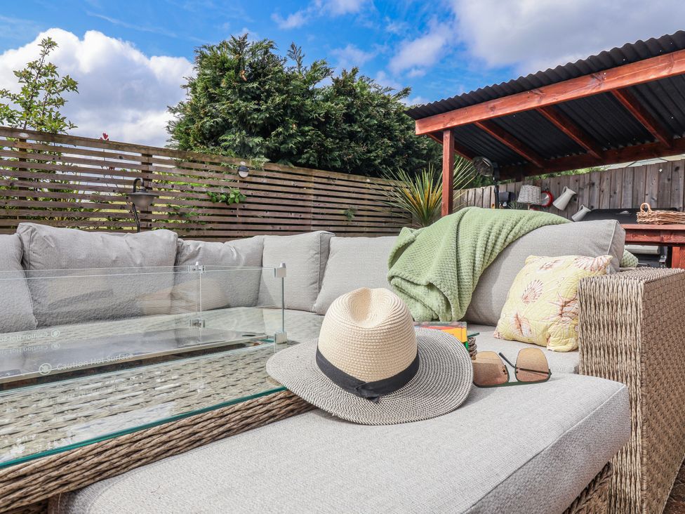 An outdoor seating area with a couch and a coffee table at Burlodge Swimbridge near Barnstaple