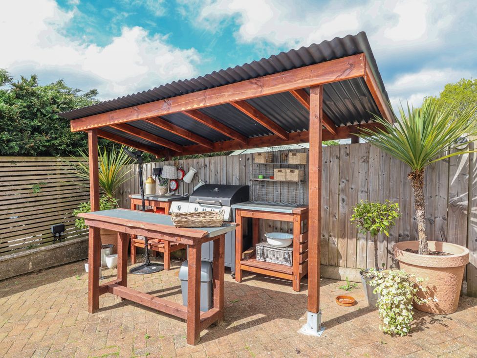 An outdoor kitchen area with barbecue grill and work table at Burlodge Swimbridge near Barnstaple