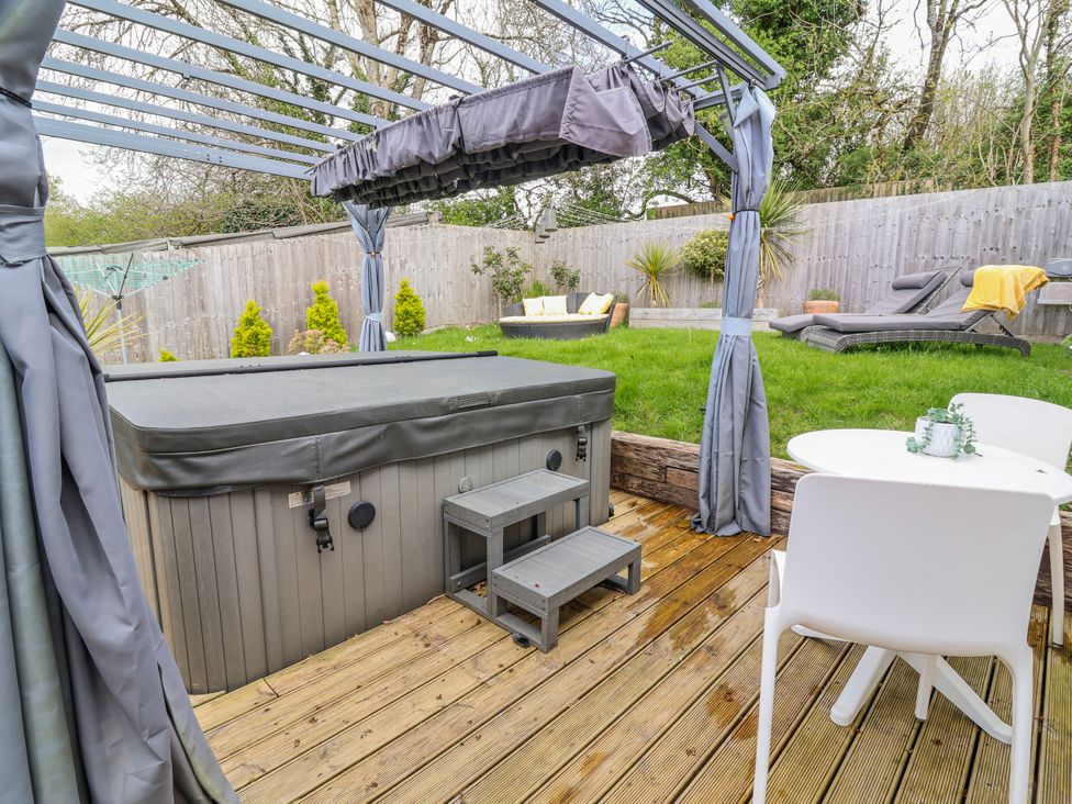 A garden with a hot tub and seating area at Burlodge Swimbridge near Barnstaple