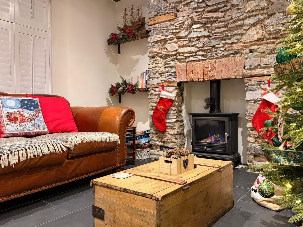 A living room with a sofa and fireplace at The Nook in Brixham