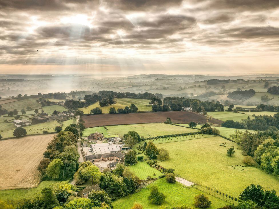 An aerial view of fields and a farmhouse at Bay Tree Cottage in Turnditch near Belper