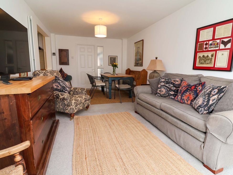 A living room with a sofa, armchair, tv, and dining table at Poplar Farm Studio in Hatton Heath near Aldford