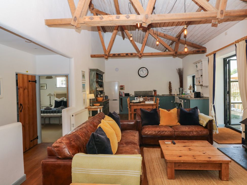 A living room with a sofa and dining area at Burrows Venn Ottery near Sidmouth